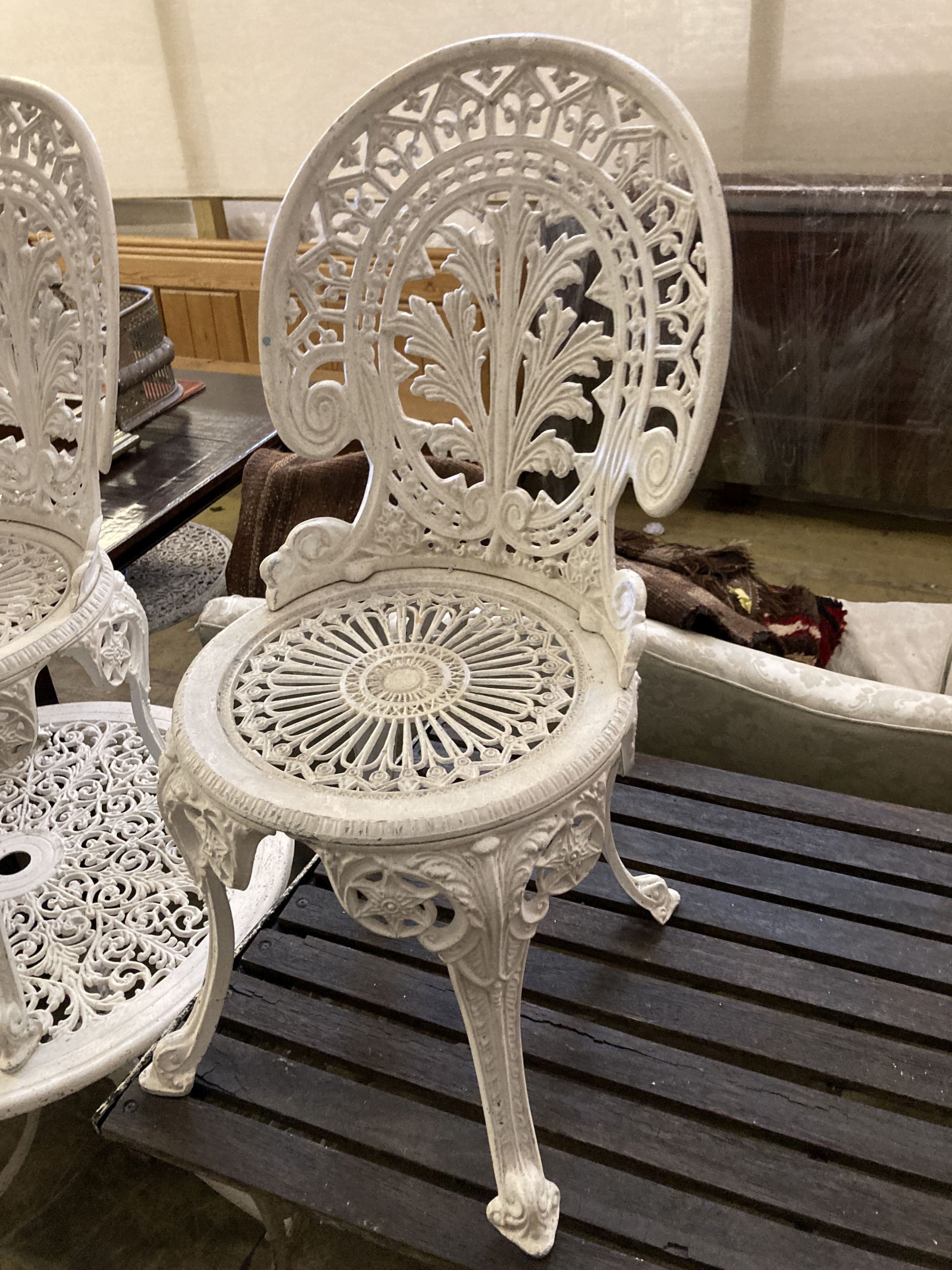 A Victorian style painted aluminium circular garden table, 69cm diameter together with a set of four similar chairs